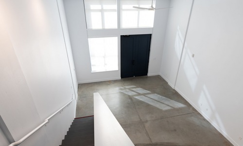 view looking down staircase to workspace landing and entrance